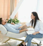 Session with a psychologist, psychotherapist. Young depressed male patient and professional female doctor with note pad. Lifestyle. Mental health care. las almas