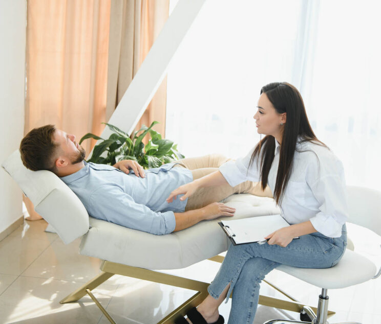 Session with a psychologist, psychotherapist. Young depressed male patient and professional female doctor with note pad. Lifestyle. Mental health care. las almas