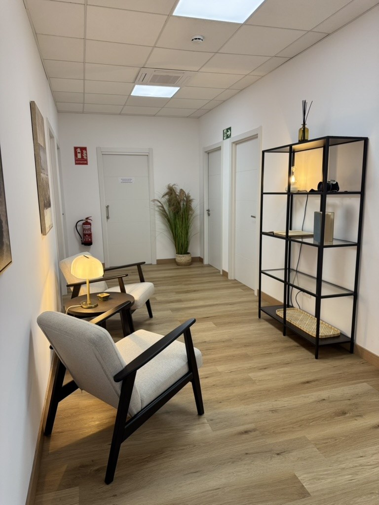 Flur im Las Almas Institut Palma de Mallorca mit Sessel, Regal und Blick zu den Behandlungsräumen